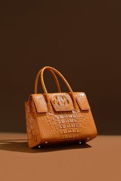 FashionByTeresa LETO Satchel Handbag Introducing the Leto Handbag – a symphony of style and sophistication for the contemporary fashion aficionado. Crafted from the finest crocodile-embossed leather, this handbag is a masterpiece that combines luxury with practicality. Its sumptuous cognac shade adds a touch of aristocratic charm to any attire, making it a versatile addition to both daywear and evening outfits. Description: Real Crocodile Satchel Handbag made of real crocodile hornback skin, Metal Stainless Steel Gold or Silver Size: 31*23*13 CM/ 12.2 x 9.06 x 5.12 inches MODEL #: Lfbt24001 Open top with magnetic closure Lamb skin Interior, zip pouch Top zipper closureLuxury quality hardware The interior features a zipper pocket, phone, and doc. pocket Hand Sawn Rolled shoulder straps The Hand Saw, Evening Outfits, How To Make Handbags, Greek Goddess, Satchel Handbags, Zip Pouch, Open Top, Contemporary Fashion, Magnetic Closure