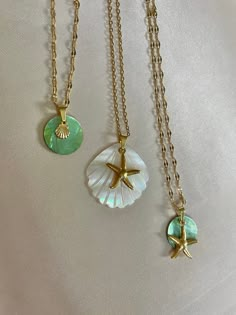 FREE UK DELIVERY FOR A LIMITED TIME ONLY.  18 karat gold plated seashell / starfish necklaces with natural shell and mother of pearl. 40-45cm All gold wear is stainless steel, water safe and resistant to tarnish.  Natural green Akoya shell & baby seashell charm (vintage style chain) Carved seashell mother of pearl with starfish charm (cable chain) Natural green Akoya shell with starfish charm (vintage style chain) Each shell is unique.  Items are dispatched within 2 working days and sent Royal M Gold Starfish Clavicle Chain Necklace, Gold Starfish Charm Necklace, Dainty Shell Necklaces Perfect As Gifts, Gold Charm Necklace With Starfish Charm, Ocean-inspired Gold Round Pendant Jewelry, Gold Ocean-inspired Round Pendant Jewelry, Gold Starfish Shell Necklace With Starfish Charm, Gold Shell Necklace With Starfish Charm, Gold Shell-shaped Necklace With Starfish Charm