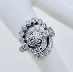 a diamond ring is shown on top of a white napkin with the center stone surrounded by smaller diamonds