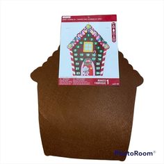 a brown potted planter with a card in the top and an image of a gingerbread house on it