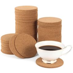 a cup of coffee sits next to some cork coasters