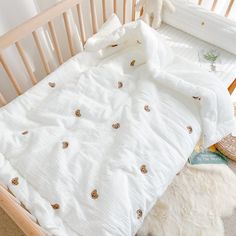 an unmade bed with white sheets and teddy bear