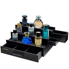 an assortment of perfume bottles on a black tray