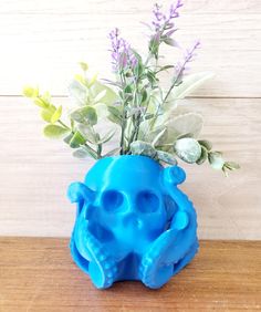 a blue vase filled with flowers on top of a wooden table