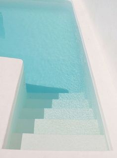 an empty swimming pool with steps leading up to it