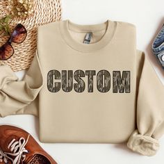 Custom Bottomlands Camo Crewneck| Camo Mama Crewneck| Camo Auntie Sweatshirt| Camouflage Crewnecks For Women And Men | Retro Custom Camo **Please leave what you want your crewneck to say in the personalization box with the correct spelling** Material & Wash: Sublimated onto an 50% cotton, 50% polyester crewneck. *Sublimation gives it a more vintage look* Tumble dry low setting or hang to dry. Machine wash cold and wash inside out. Do not iron or dry clean. Sizing & Fit: True to size Size up one Camouflage Cotton Crew Neck Sweatshirt, Fall Camouflage Crew Neck Sweatshirt, Fall Camouflage T-shirt With Crew Neck, Camouflage Crew Neck Top For Fall, Fall Camouflage Crew Neck T-shirt, Fall Camouflage Crew Neck Top, Casual Camouflage Crew Neck Sweatshirt, Crewnecks For Women, Auntie Sweatshirt