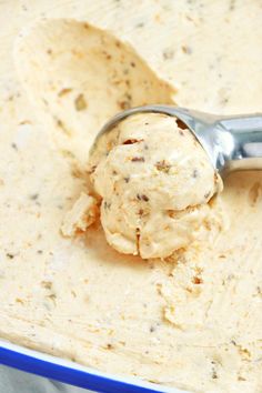 a scoop of ice cream in a blue bowl with a metal spoon on the side