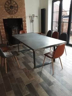 a dining room table and chairs in front of a fireplace