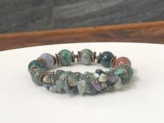 "Experience the earthy and grounding energy of Indian Agate with this exquisite gemstone bracelet. It features large 12mm Indian Agate round beads and the delicate charm of Agate chip stones, creating a harmonious blend of sizes and textures. Antique bronze spacers add a touch of rustic elegance to the design, enhancing the overall aesthetic. Indian Agate is celebrated for its stabilizing and protective qualities, making it an ideal choice for daily wear. Crafted with high-quality stretch cord, Chip Bead Jewelry, Aesthetic Indian, Grounding Energy, Indian Agate, Chip Beads, Bead Jewelry, Agate Beads, Rustic Elegance, Agate Gemstone