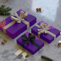 three purple wrapped presents sitting on top of a table next to pine cones and nuts