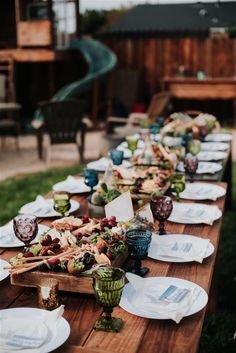 a long wooden table with plates and bowls on it