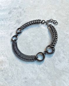 Hello! I made this DOUBLE MOON Festival Choker Necklace in Gunmetal Black Color using strong & skin-friendly, hypoallergenic aluminum rings, with the ancient craft of chainmail. * This handmade accessory will look elegant & unique on your neck. (Be ready for curious questions ;) 🎁 It would be a perfect gift for a loved one, friend or a stylish family member 🎁 - Was made with the mix of Full Persian & Byzantine chainmail patterns. - All the rings were attached to each other one by one by hand. - Clasp is stainless steel. HOW TO TAKE CARE OF YOUR ACCESSORY? * Anodized aluminum jump rings are treated with a special coating that helps protect the metal from scratches and corrosion, as well as giving them a vibrant color. However, even with this coating, the metal can still be prone to scratc Gothic Gunmetal Jewelry With Chain, Gothic Gunmetal Chain Jewelry, Black Stainless Steel Chainmail Jewelry, Round Black Metal Chain Bracelet, Gothic Stainless Steel Chainmail Jewelry, Stainless Steel Jewelry Making Jump Rings, Medieval Hand Forged Metal Jewelry, Medieval Style Hand-forged Metal Jewelry, Gunmetal Metal Chain Bracelet For Gift