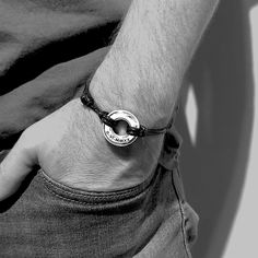 black and white photograph of man wearing a bracelet with the word love written on it