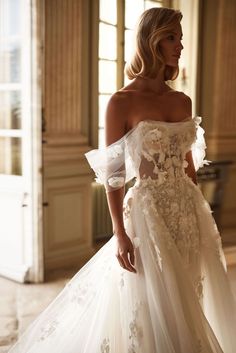 a woman in a white wedding dress is looking off to the side