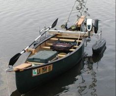 a small boat is sitting in the water with two oars on it's side