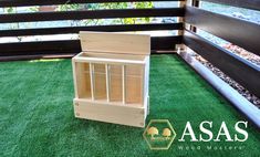 a wooden doll house sitting on top of green grass