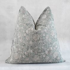 a gray and white pillow sitting on top of a table