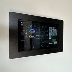 a black wall mounted display with various controls on it's sides and an image of a house