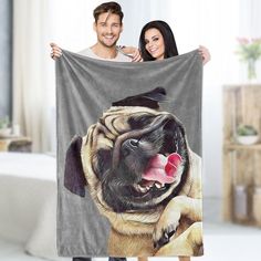 a man and woman holding up a blanket with a dog on it's face