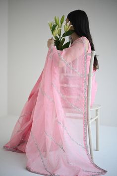 This beautiful stitched pure teapink organza saree is heavily embellished with silver hand craftmenship expertly done by our chosen artisans, taking upto 400+ hours, paired with a stitched pure raw silk blouse. Order Duration: 4 to 6 weeks Silver Organza Sharara With Resham Embroidery, Silver Organza Sharara For Festive Occasions, Silver Pre-draped Saree With Mirror Work, Bollywood Style Silver Organza Sharara, Festive Silver Organza Sharara, Pink Bollywood Style Pre-draped Organza Saree, Silver Organza Dupatta With Resham Embroidery, Designer Silver Saree With Resham Embroidery, Silver Organza Sharara With Dupatta