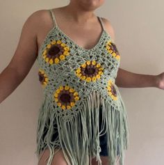 a woman wearing a crocheted top with sunflowers on it