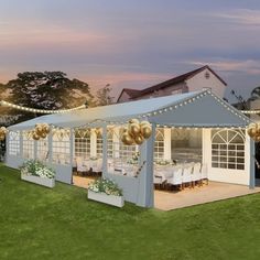 a large party tent set up with tables and chairs for an outdoor event at dusk