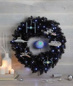 a star wars wreath with lights and ornaments on a table next to a white candle