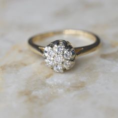 Vintage mid-century diamond cluster ring dating to about the 1950s. It has a raised design for a high-impact look. Each stone is about .05 ct for a ctw of .35 ct.  Era: c.1950s Markings: 14k, Makers mark (W in a diamond frame) Ring Size: 6.5 (your order comes with one free resizing by our jeweler) Condition: Excellent antique condition with minor surface wear from age  Shipping is free in the United States Follow on Instagram @LUXXORVintage Mid Century Ring, Classic 14k Gold Cluster Diamond Ring, Heirloom Cluster Ring In Diamond White, Antique Cluster Diamond Ring With Center Stone, Classic Cluster Promise Ring, Diamond Cluster Ring With Diamond Cut, Timeless Cluster Diamond Promise Ring, Heirloom Style Cluster Ring With Brilliant Cut, Heirloom Style Brilliant Cut Cluster Ring