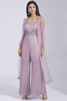 Lilac plain flared jumpsuit with front open sheer long jacket. This set comes with embellished belt.
Components: 3
Fabric: Satin Linen , silk Organza 
Neckline: Jumpsuit: Sweetheart; Jacket: Lapel
Sleeve Length: Jumpsuit: Sleeveless; Jacket: Full
Color: Purple
Embroidered
Front open jacket
Noodle straps
Cutwork belt
Closure: Jumpsuit: Back zip - Aza Fashions Jumpsuit With Jacket, Jumpsuit Outfit Wedding, Fancy Jumpsuit, डिजाइनर कपड़े, Flared Jumpsuit, Trendy Outfits Indian, Birthday Outfit For Women, Simple Frocks, Indian Dresses Traditional