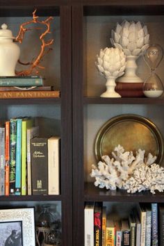 two bookshelves with vases and other decorative items on top of each shelf