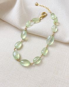 The color of these gorgeous prehnite gems reminds me of the sun shining through new spring leaves. They shimmer and glow with every movement, catching the light in the most enchanting way. I have wire-wrapped each faceted oval gem by hand in 14K gold fill, forming a simple, elegant chain. The extender allows for an adjustable fit for most wrists. Bracelet length: 7 inches plus 1-inch extender Materials: prehnite, gold fill Elegant Jewelry With Natural Stones And Chrysoprase, Elegant Chrysoprase Jewelry With Natural Stones, Elegant Green Citrine Jewelry, Green Moonstone Jewelry With Natural Stones, Elegant Prehnite Gemstone Jewelry, Delicate Green Jewelry With Natural Stones, Elegant Peridot Jewelry With Natural Stones, Elegant Chrysoprase Jewelry For Healing, Elegant Adjustable Light Green Jewelry