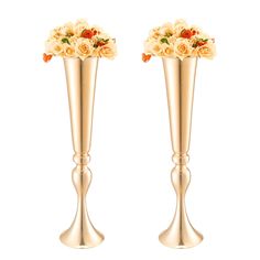 two gold vases with flowers in them on a white background, one is filled with orange and the other has red roses