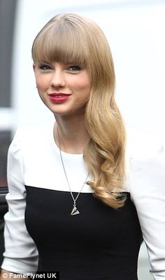 a woman with long blonde hair wearing a black and white dress