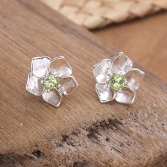 Many cultures associate peridot stones with prosperity and good fortune, as their green tone brings to mind Earth's abundance. Using these gems as the centerpiece, Balinese artisan Wayan Lasti crafts a pair of sterling silver stud earrings in a sweet flower shape. The accessory features a high polish finish for an elegant accent. Green Tone, Baroque Art, Peridot Stone, Sterling Silver Stud Earrings, Green Tones, Silver Stud Earrings, Good Fortune, Balinese, Sterling Silver Studs