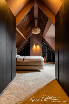 an attic bedroom with a bed and two lamps on the ceiling, along with carpeted flooring