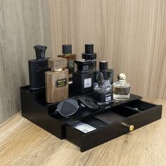 a wooden table topped with lots of different types of perfumes and bottles on top of it