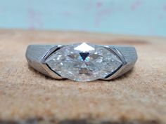 a diamond ring sitting on top of a wooden table