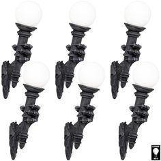 a set of four black and white street lights with frosted glass balls on them