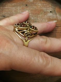 This is the last ring in a set of 5, that I bought in southern Indiana. It's a remarkable Huge 14K ladies Garnet Cluster ring. It weighs a hefty 11.0 grams, and the top measures 24mmx22m. There are 7-6x4mm medium red oval Garnets set with 6 prongs each. There a beaded pattern around each Garnet, and has a scrolled heart design on each side. There are some very fine scratches on a few stones that are considered normal for everyday wear. Its not noticeable unless looking under a 10x loupe. It's a Victorian Brass Rings For Anniversary, Unique Hallmarked Brass Rings, Antique Hand Forged Rings For Formal Occasion, Unique Brass Rings For Formal Occasions, Antique Hallmarked Brass Rings, Oval Brass Rings For Anniversary, Unique Hallmarked Skull Ring For Anniversary, Anniversary Brass Oval Rings, Vintage Collectible Skull Ring