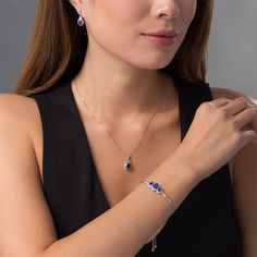 Wow her with this charming three-piece set. Crafted in sterling silver, the pendant showcases an 8.0 x 6.0mm oval-shaped lab-created bright blue Ceylon sapphire wrapped in a frame of lab-created white sapphires topped with a baguette-cut created sapphire - all suspended along an 18.0-inch box chain that secures with a lobster claw clasp. The drop earrings each feature a 7.0 x 5.0mm oval-shaped created blue Ceylon sapphire in a similar look. These post earrings secure comfortably with friction ba Elegant Sterling Silver Gemstone Jewelry Sets, Sapphire Cubic Zirconia Jewelry Sets, Fine Jewelry Sets In Sapphire Sterling Silver, Sapphire Sterling Silver Jewelry Sets, Sapphire Sterling Silver Fine Jewelry Sets, Fine Jewelry For Anniversary With Sterling Silver Clasp, Elegant Dangle Birthstone Jewelry, Formal Dangle Birthstone Jewelry, Sapphire Sterling Silver Jewelry Sets For Anniversary