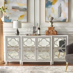 a living room with two chairs and a sideboard