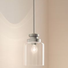 a clear glass light fixture hanging from a ceiling in a room with white walls and flooring