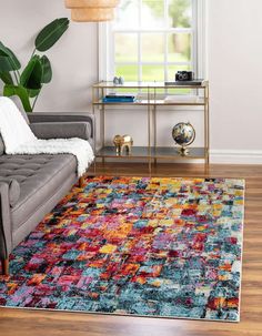 a living room with a gray couch and colorful rug