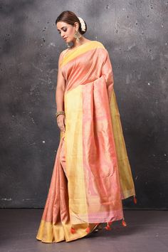 Radiate ethnic elegance on festive occasions in this gorgeous peach handloom Kanjivaram silk saree. The saree is adorned with a contrasting yellow zari border and pallu. It comes with a matching blouse piece. Shop handloom sarees in USA from Pure Elegance. Disclaimer: The shown stitched blouse on the model is for display purpose only. The saree comes with a matching blouse piece and finished with fall and piko. Tussar Silk Sarees, Kanjivaram Silk Saree, Latest Designer Sarees, Fashion Journals, Pure Elegance, Tussar Silk Saree, Indian Saree, Traditional Fabric, Pure Silk Sarees