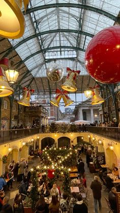 the inside of a shopping mall with christmas decorations on the ceiling and lights hanging from the ceiling