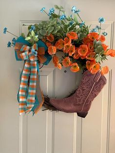 an orange and blue wreath with boots hanging from it's side on a white door