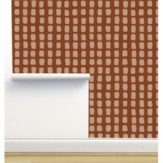 a brown and white wallpaper with squares in the center, on top of a wooden floor