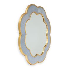 a blue and gold flower shaped mirror on a white wall