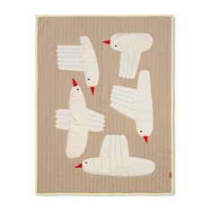 four white birds sitting on top of a beige quilted wall hanging from the side