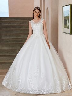 a woman in a white wedding dress standing next to some stairs